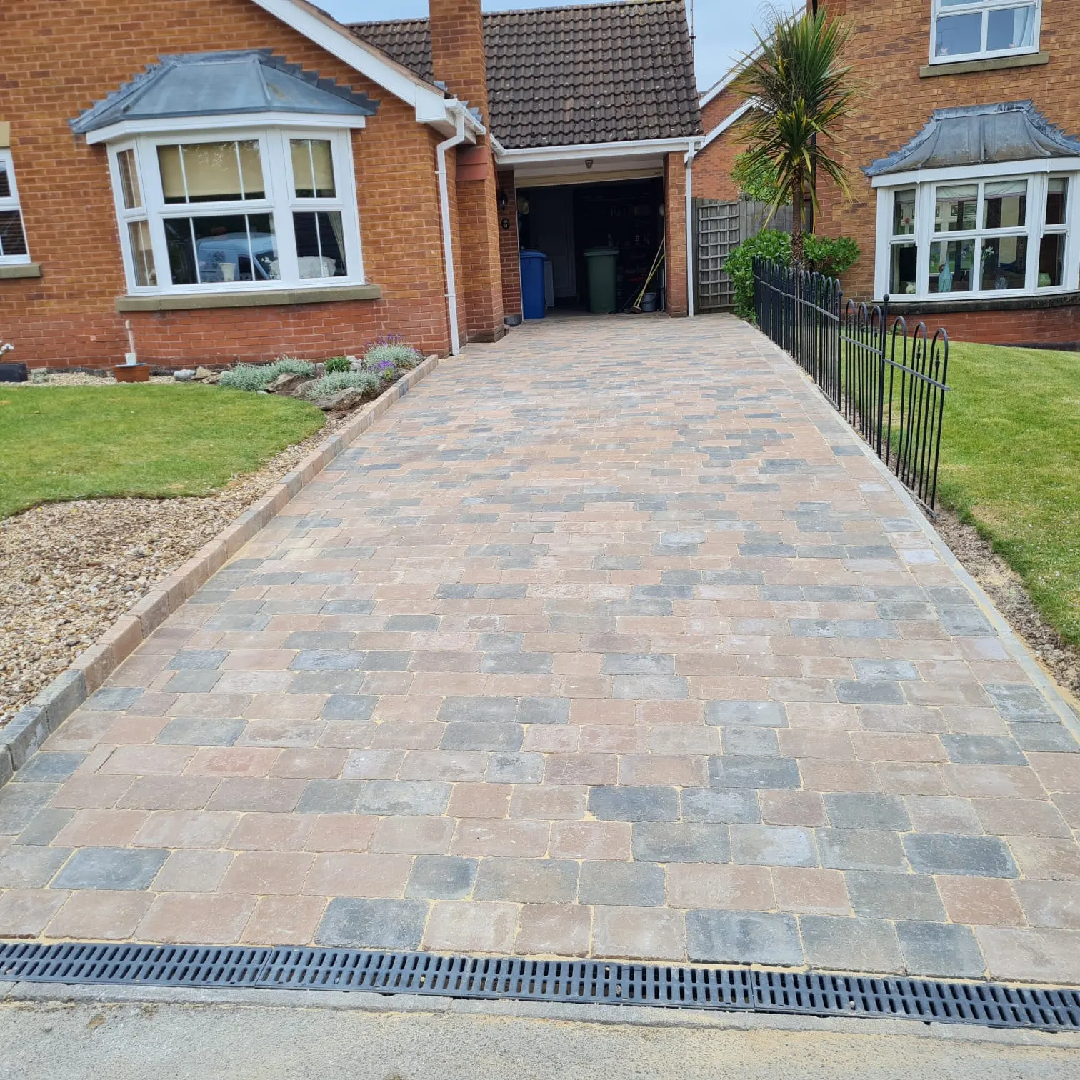 Multicolour block paving driveway with a channel drain and railings