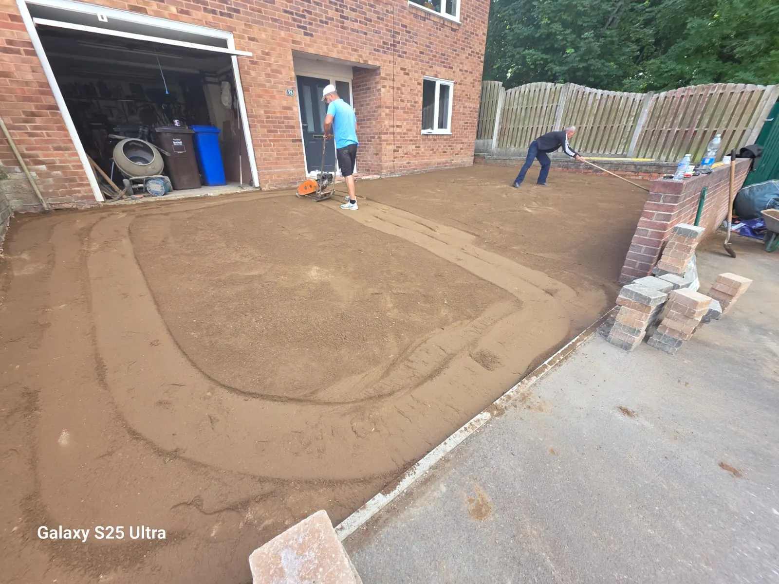 Multicolour block paving driveway with a charcoal border in front of a garage