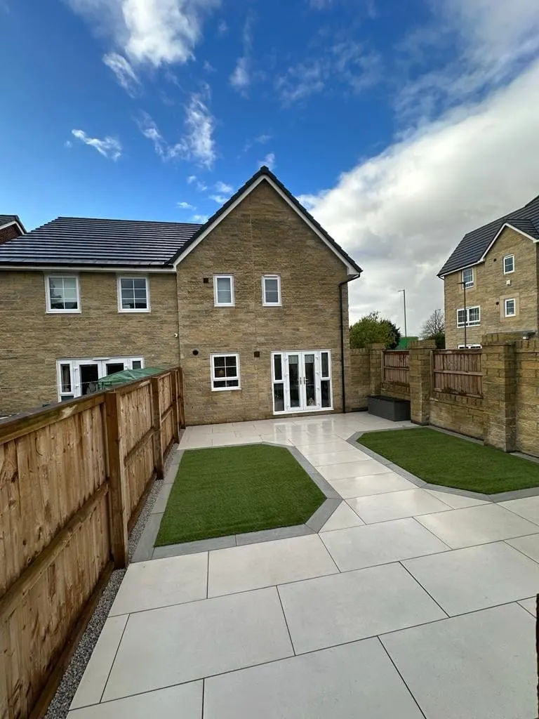 Porcelain patio with two artificial grass squares at a new-build house