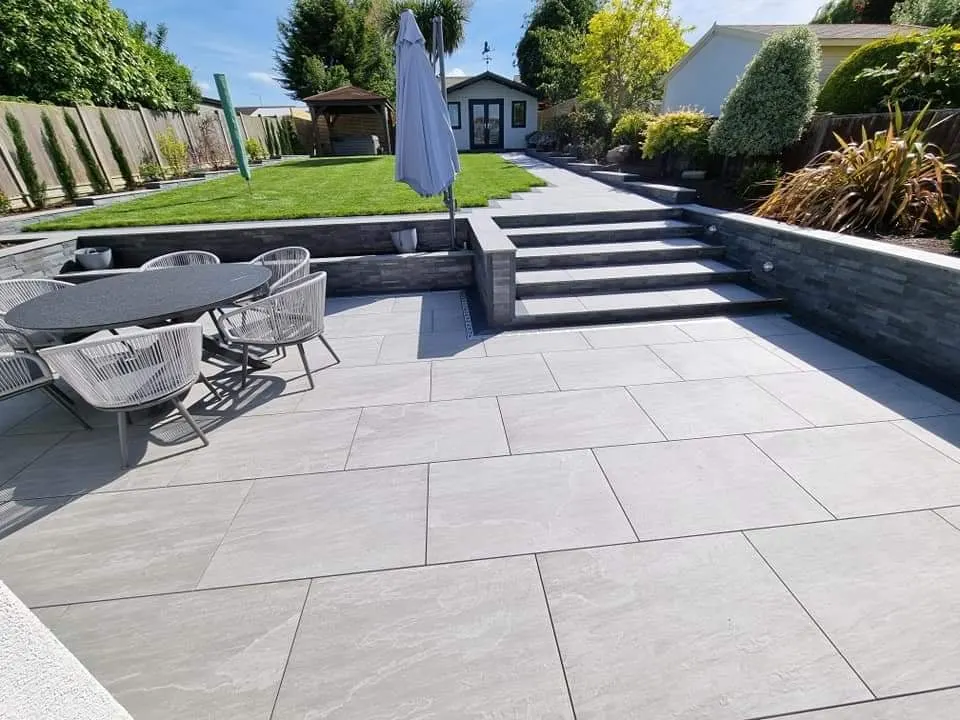 Large porcelain patio with steps and rendered garden walls