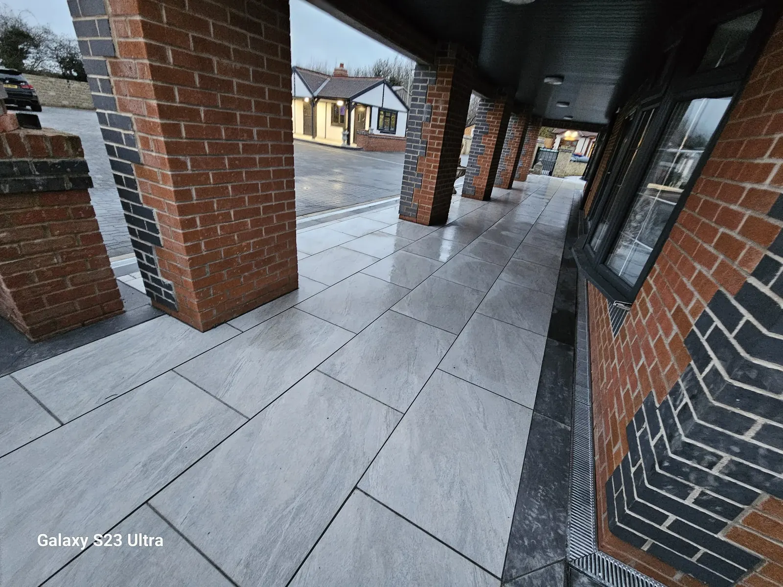 Porcelain floor along a covered veranda with brick columns