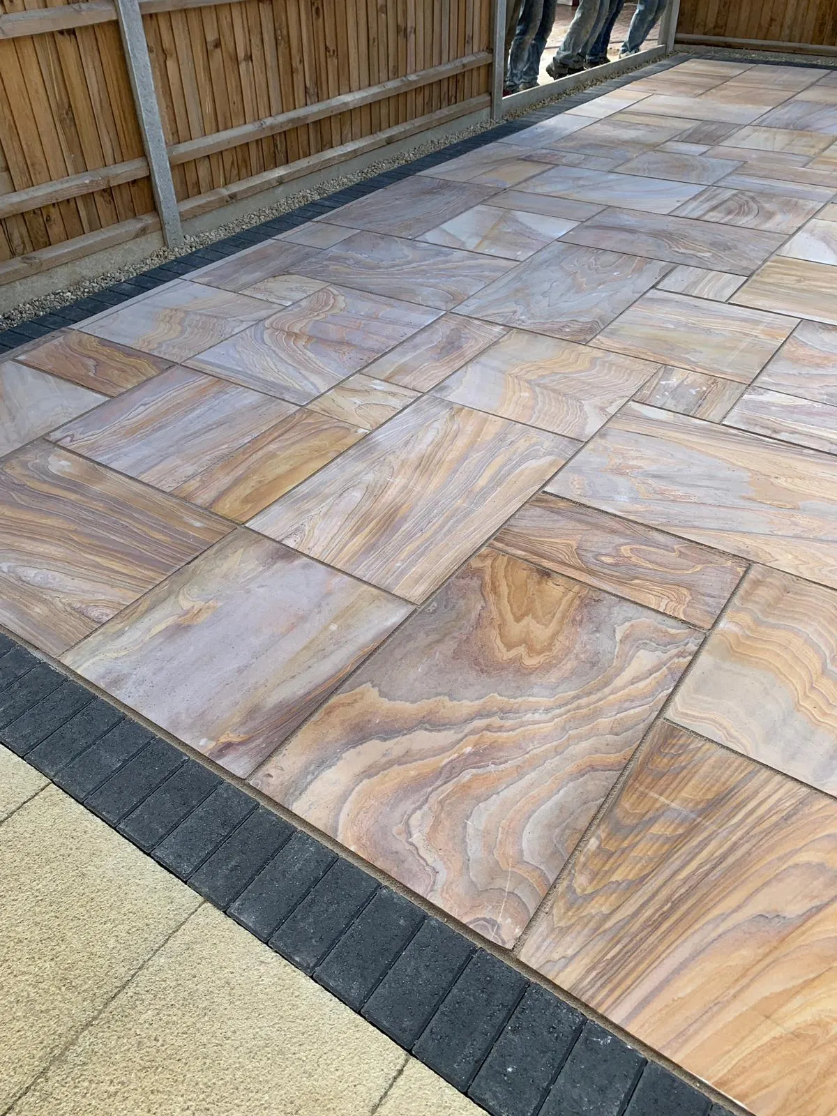 Rainbow sandstone slabs meeting a charcoal block border