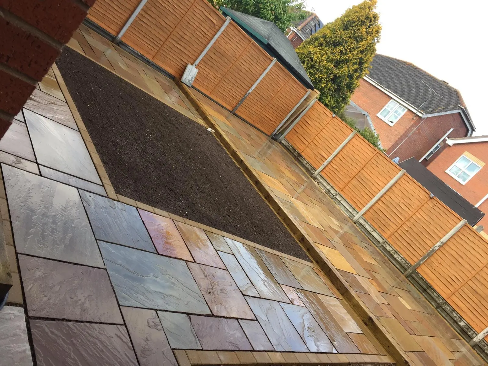 Rainbow sandstone patio with a sleeper-edged planting bed