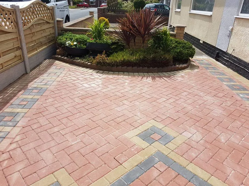 Red herringbone block paving driveway with a buff chevron and a raised bed