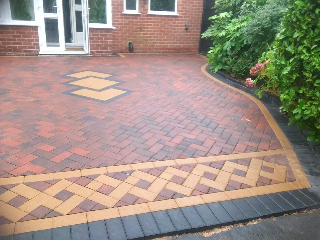 Red herringbone block paving driveway with buff diamonds and a patterned border