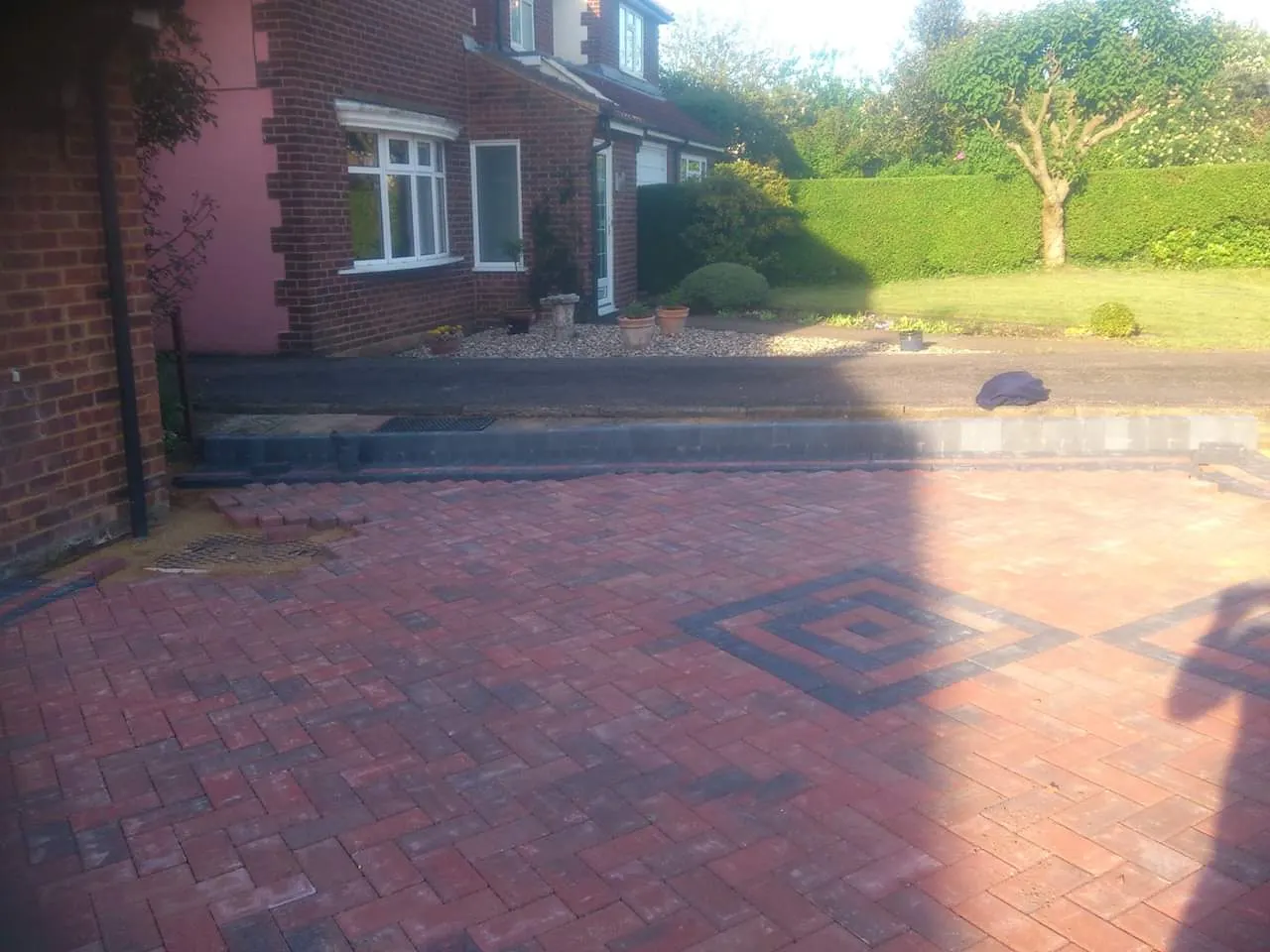 Red block paving driveway with a charcoal diamond inset