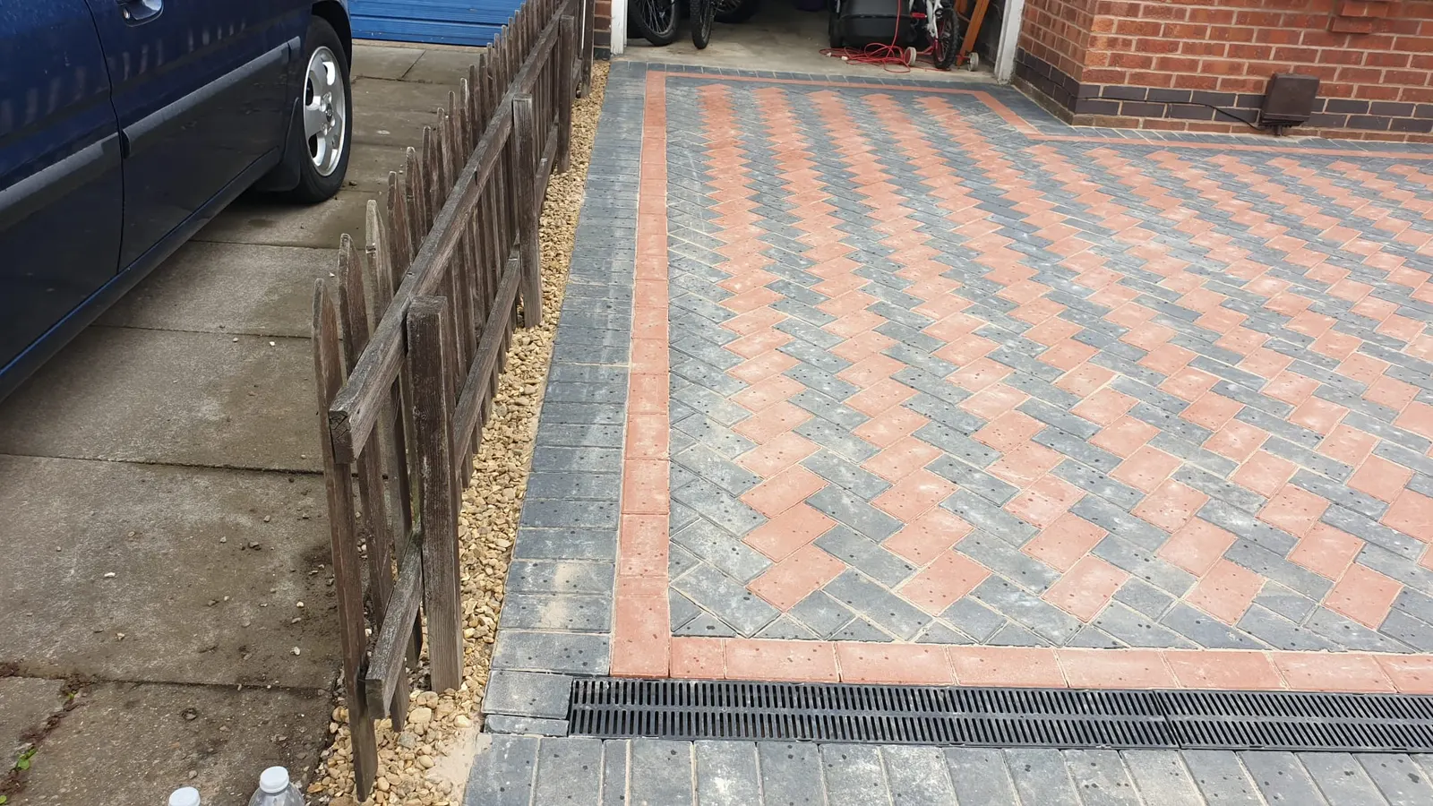Red and charcoal patterned block paving with a channel drain