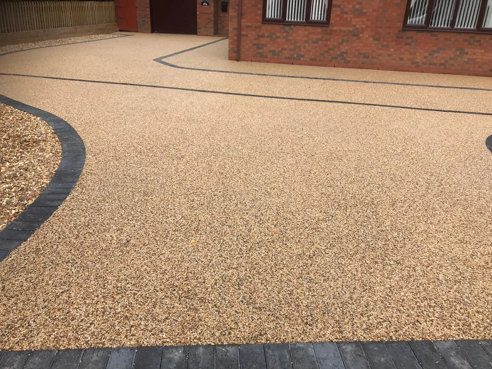 Resin bound driveway with a charcoal block border and a gravel bed