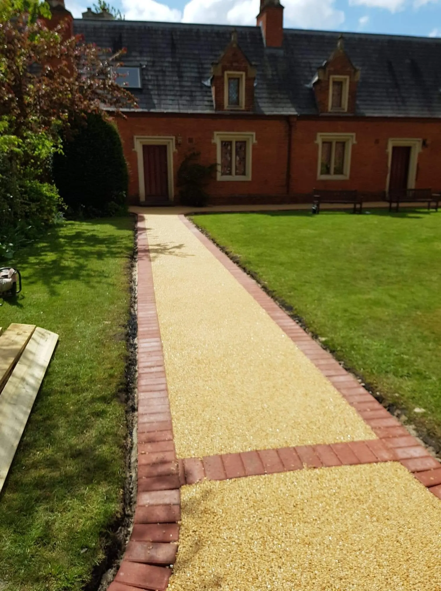 Resin bound path with red block paving edging and a cross band between lawns