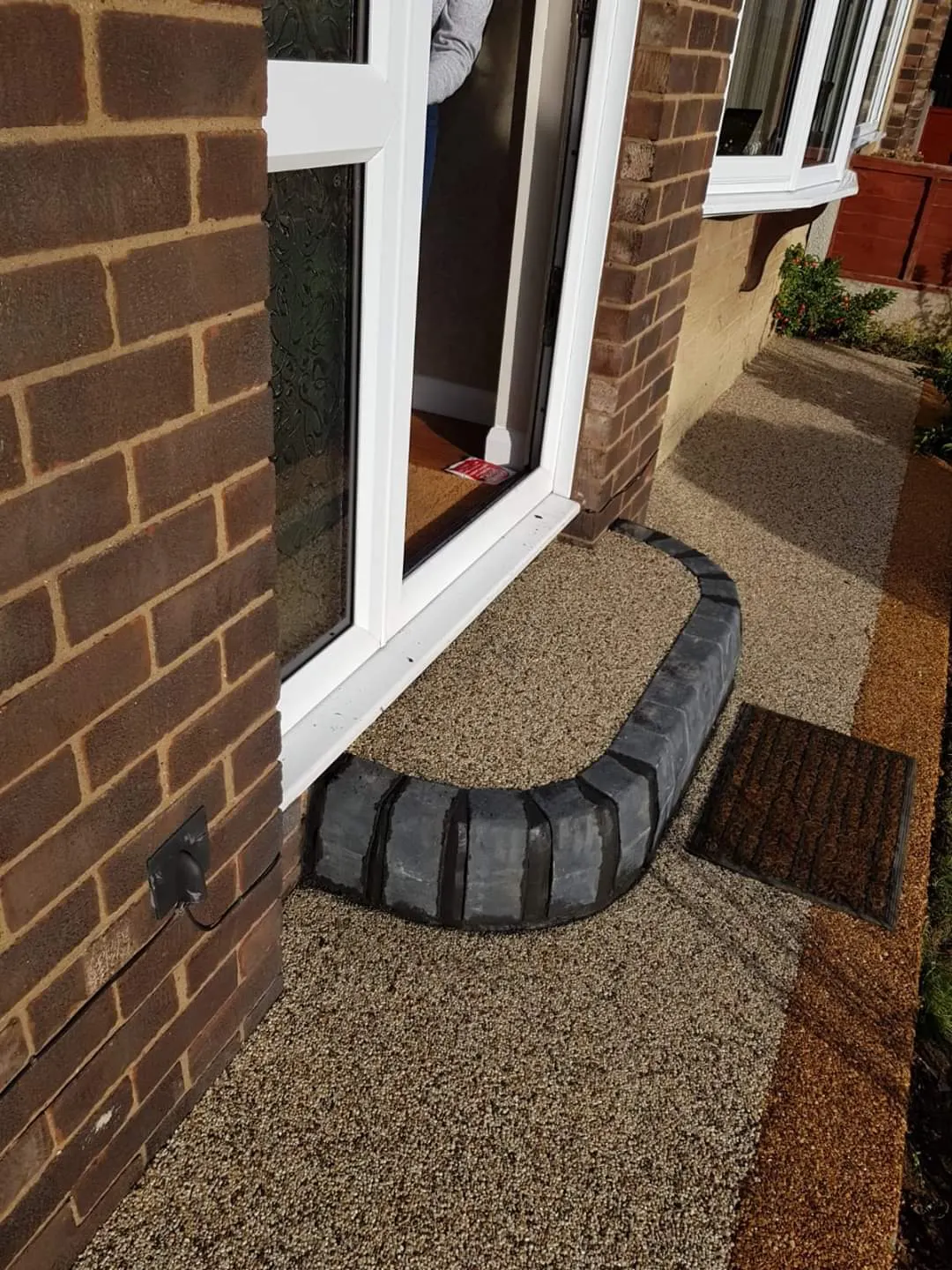 Resin bound path at a back door with a curved charcoal kerb step