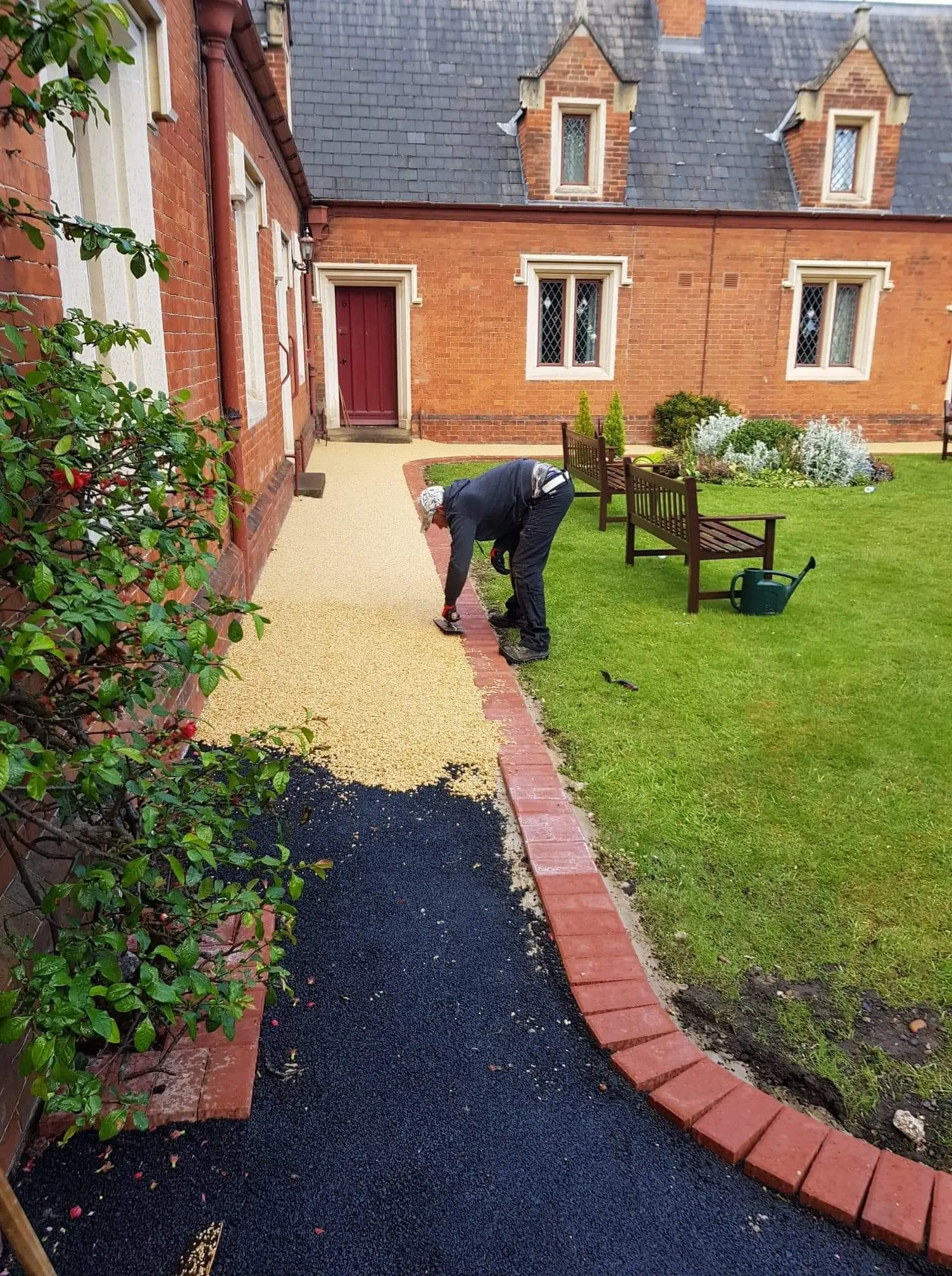 Resin bound path being laid over a tarmac base in a courtyard