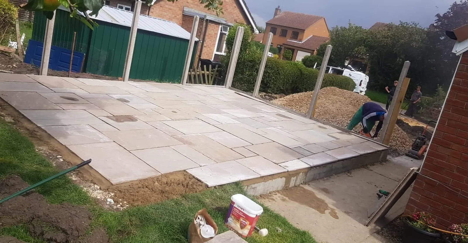 Sandstone patio being laid behind a new-build house
