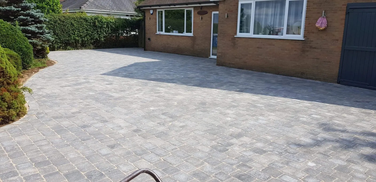 Silver-grey block paving driveway in front of a bungalow