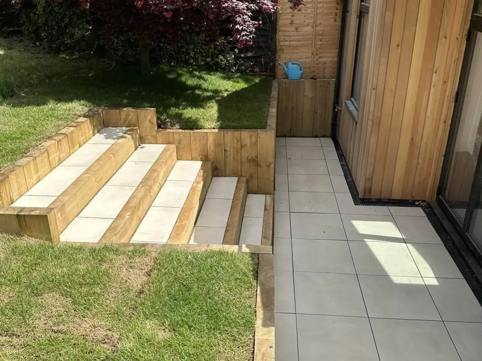 Sleeper steps with porcelain treads down to a cream porcelain patio