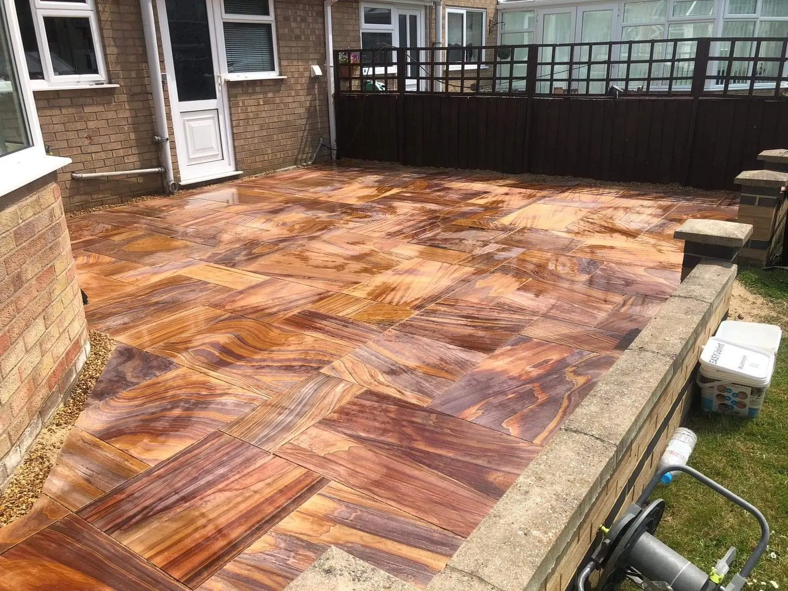 Teak sandstone patio with a low rendered wall